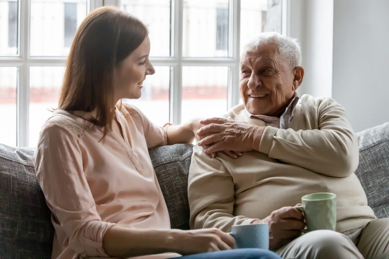 Adult daughter talking to her father about hearing loss.