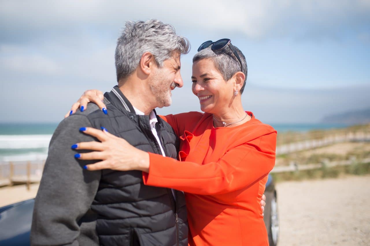 Middle-aged couple embracing at the beach.