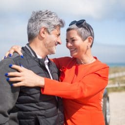 Middle-aged couple embracing at the beach.