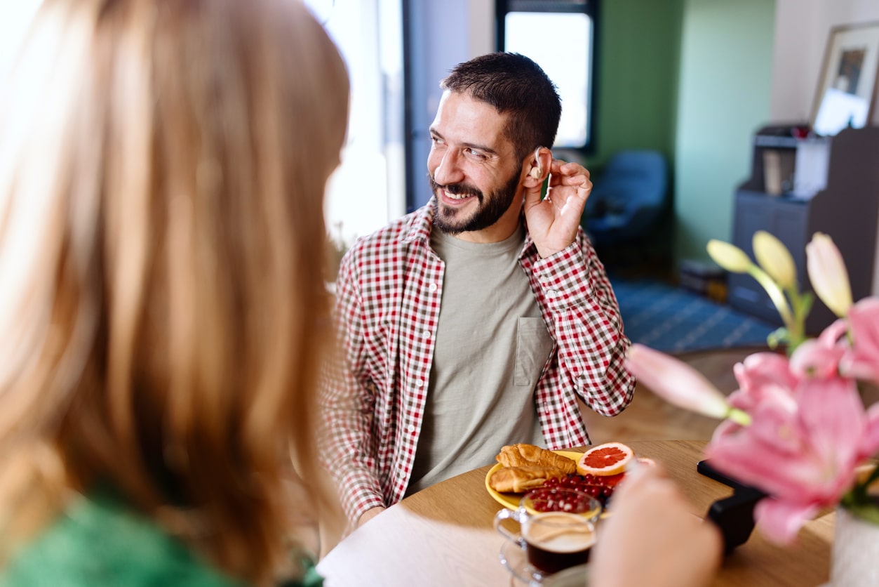 Man with hearing aid enjoys dinner