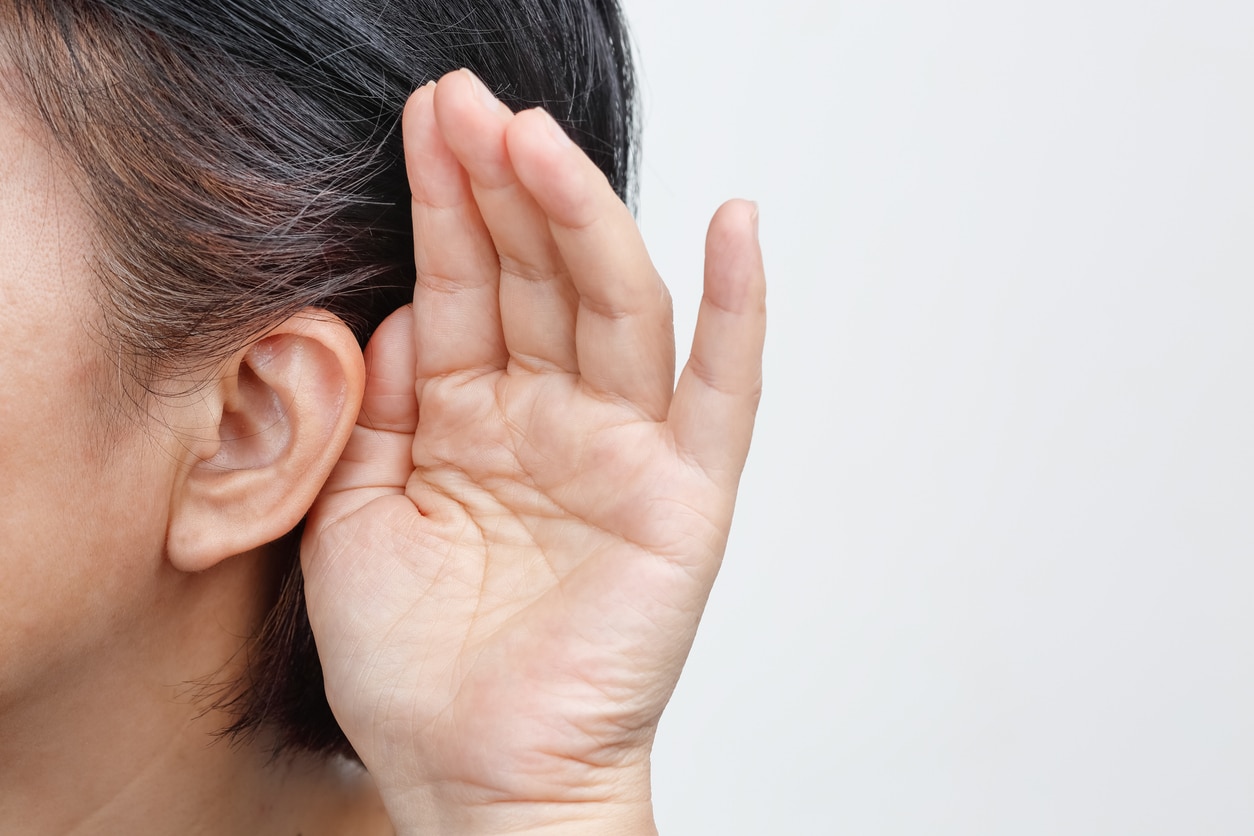 Person cups hand behind ear to hear